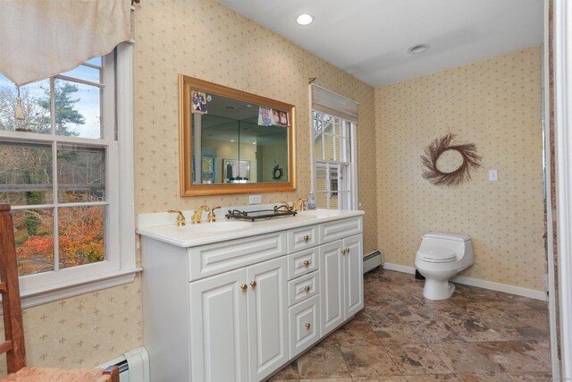 bathroom featuring a wealth of natural light, vanity, and a baseboard radiator