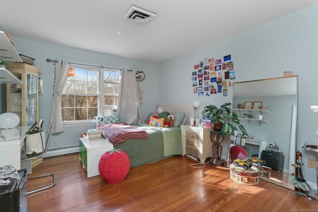 bedroom featuring hardwood / wood-style flooring and baseboard heating