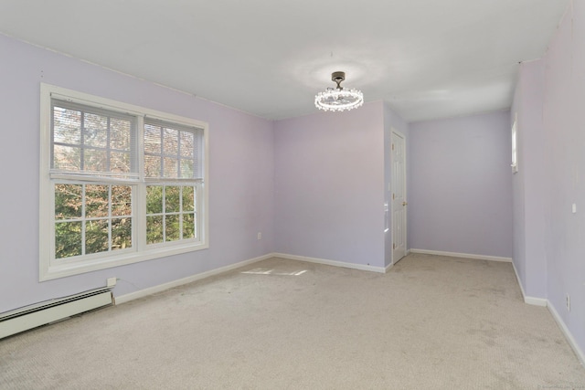 carpeted empty room featuring a baseboard heating unit and a notable chandelier