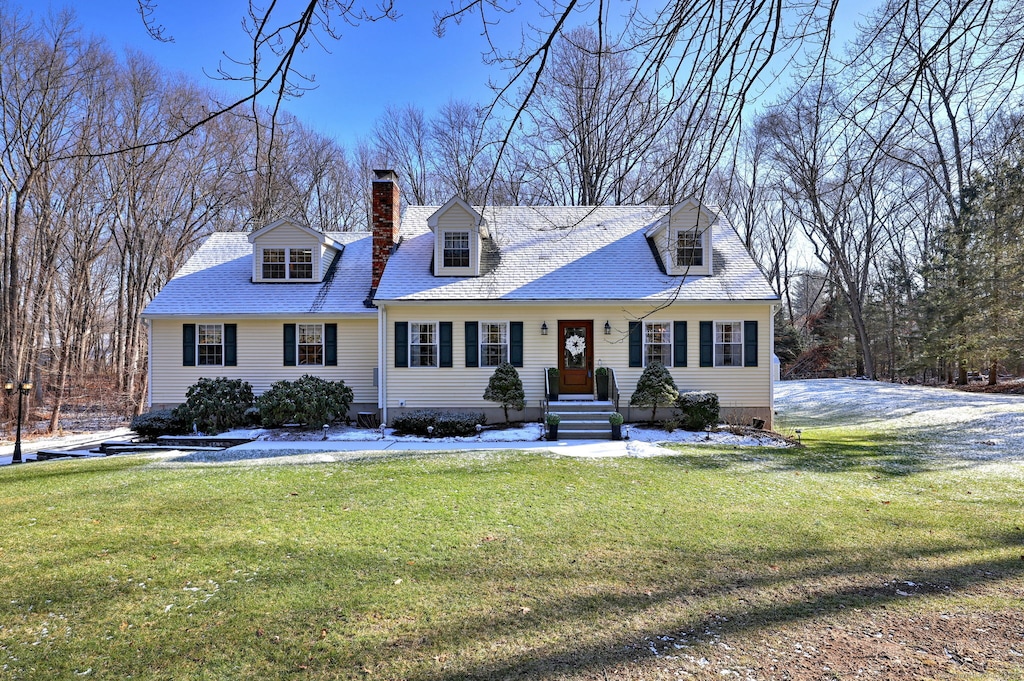 cape cod house with a front yard