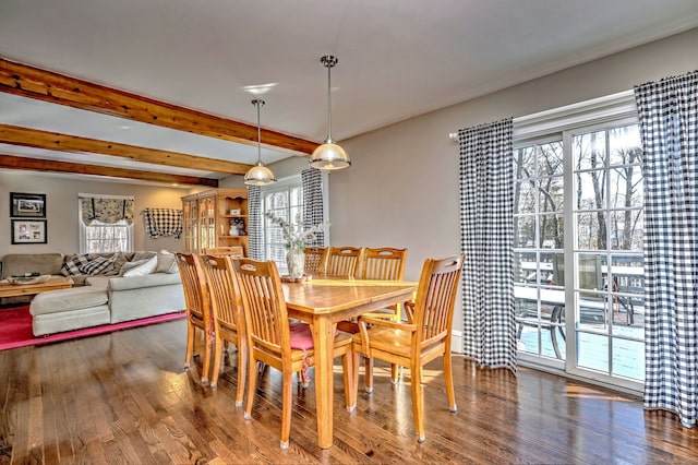 dining area featuring beamed ceiling, plenty of natural light, and wood-type flooring