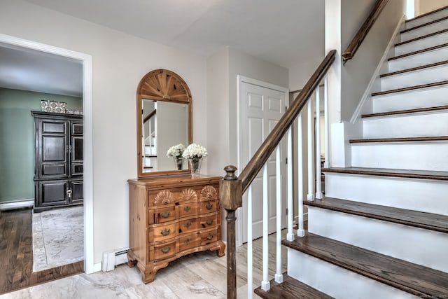 staircase with wood-type flooring and a baseboard radiator