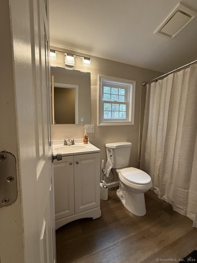 bathroom featuring vanity, wood-type flooring, and toilet