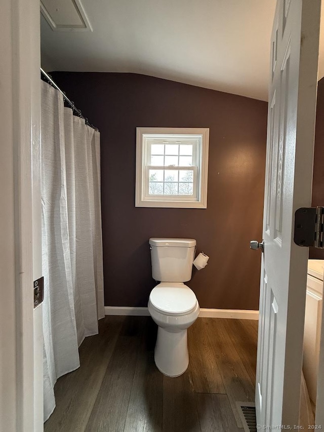 bathroom with hardwood / wood-style floors, toilet, and lofted ceiling