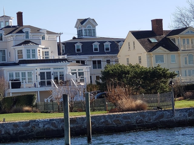 back of property featuring a water view