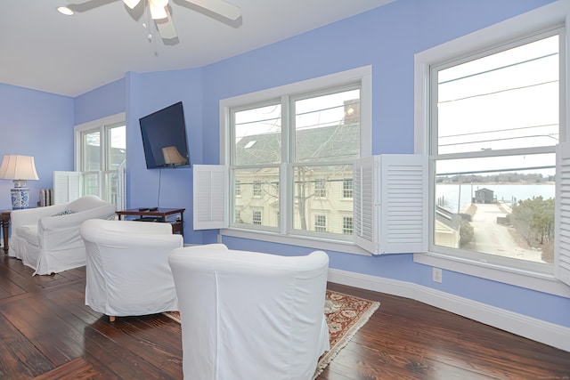 living room with dark hardwood / wood-style flooring and ceiling fan