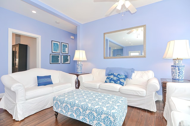 living room featuring ceiling fan and dark wood-type flooring