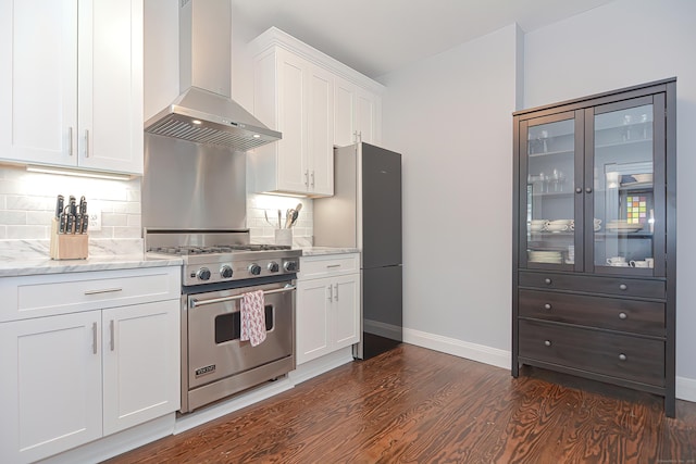 kitchen with dark wood-type flooring, white cabinets, wall chimney range hood, high end stainless steel range oven, and light stone countertops