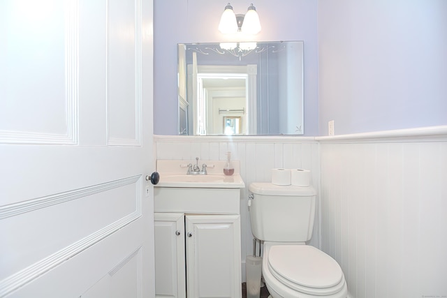 bathroom featuring vanity, a chandelier, and toilet