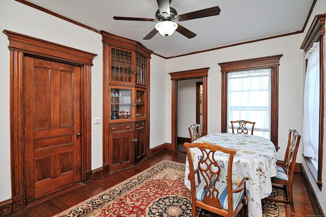 dining space with ceiling fan, crown molding, and dark wood-type flooring