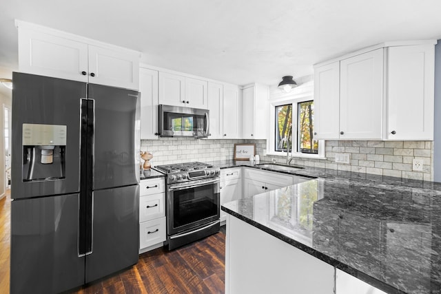 8 Fernwood Ave, Enfield, CT 06082 - kitchen with appliances with stainless steel finishes, dark stone counters, dark wood-style flooring, and backsplash