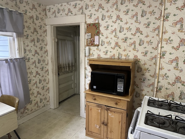 interior space featuring light tile patterned floors and white range oven