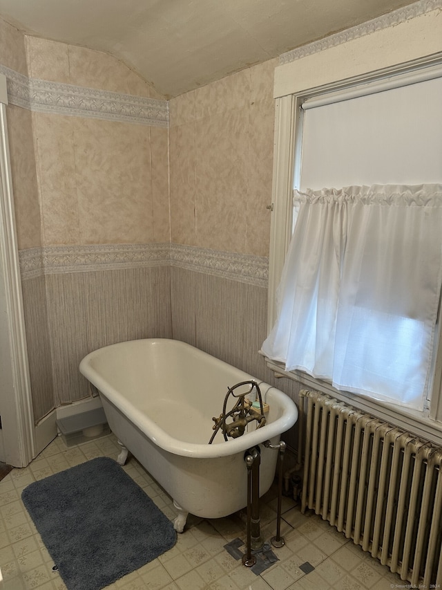 bathroom featuring vaulted ceiling, radiator heating unit, and a washtub