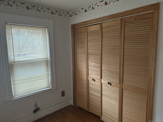 unfurnished bedroom featuring dark hardwood / wood-style floors and a closet