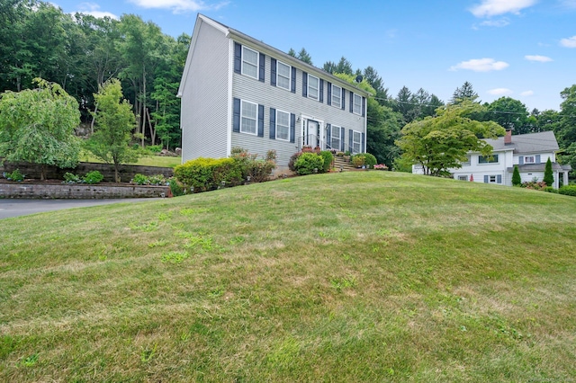 colonial house featuring a front lawn