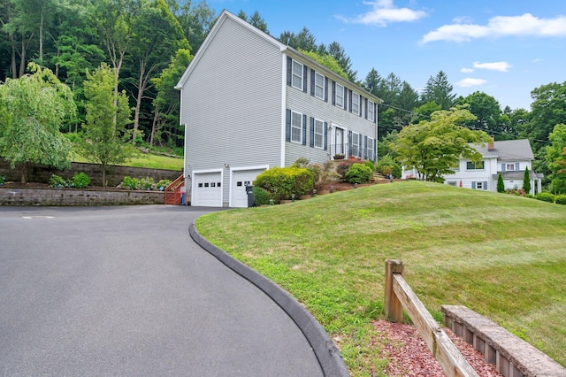 view of property exterior featuring a garage and a yard