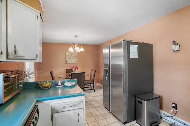 kitchen with an inviting chandelier, white cabinets, stainless steel refrigerator with ice dispenser, pendant lighting, and light tile patterned floors