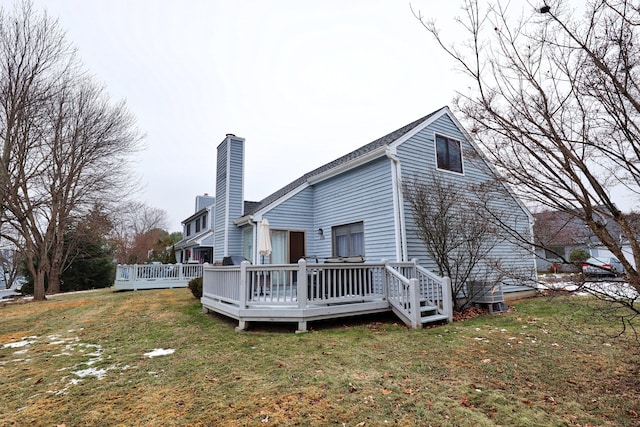 back of house featuring a lawn and a deck