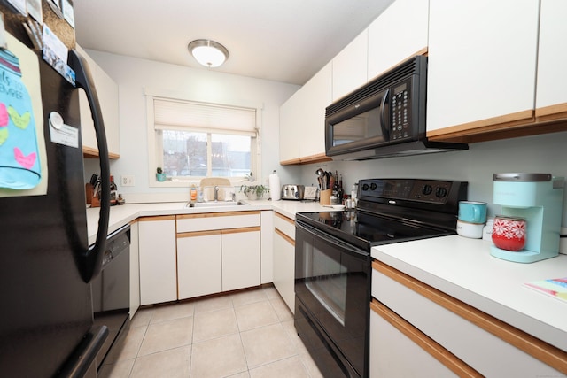 kitchen featuring black appliances, white cabinetry, light tile patterned flooring, and sink