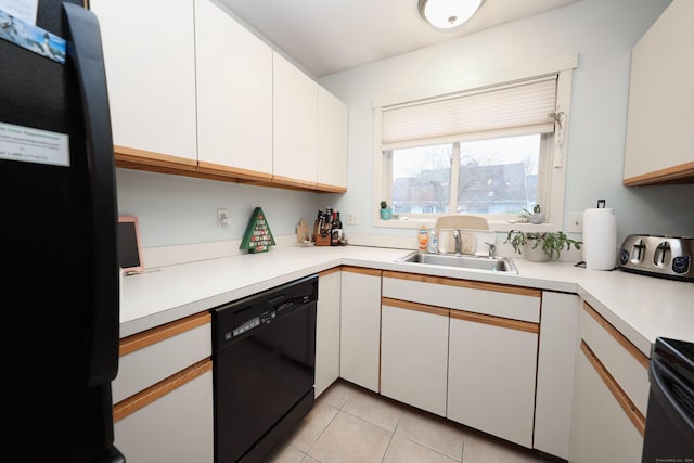 kitchen featuring sink, light tile patterned floors, white cabinetry, and black appliances