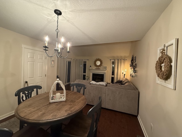 dining room featuring a textured ceiling, a notable chandelier, and dark hardwood / wood-style floors