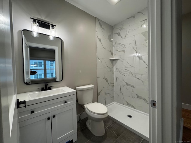 bathroom with tile patterned floors, vanity, toilet, and tiled shower