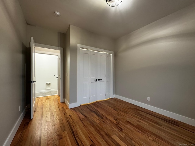 unfurnished bedroom featuring a closet and hardwood / wood-style flooring