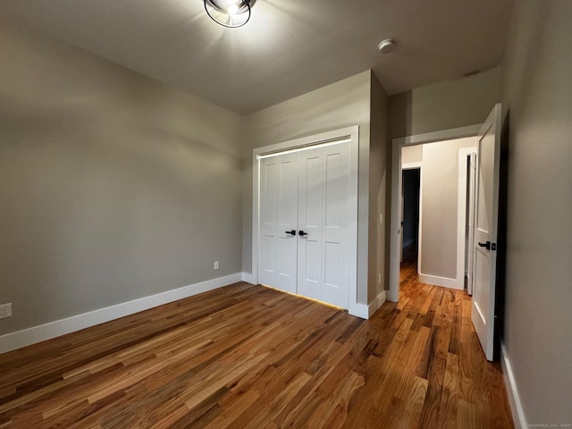 unfurnished bedroom with a closet and hardwood / wood-style floors