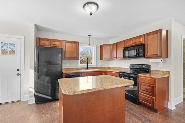 kitchen with sink, black appliances, pendant lighting, a center island, and dark hardwood / wood-style floors