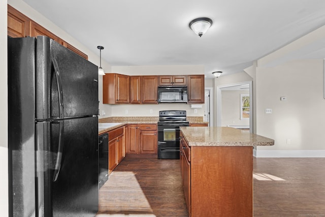 kitchen featuring pendant lighting, dark hardwood / wood-style flooring, a kitchen island, and black appliances