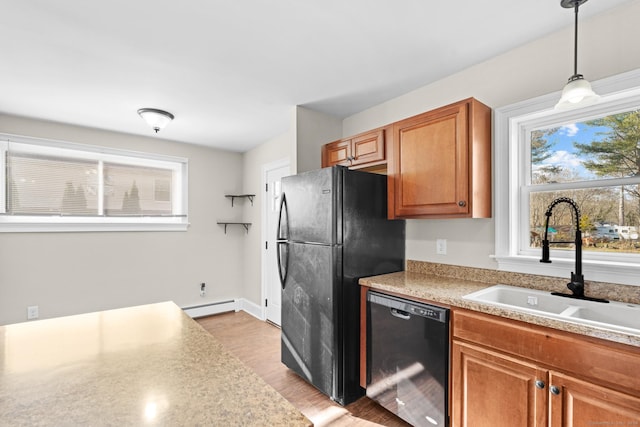 kitchen with a baseboard heating unit, black appliances, sink, light wood-type flooring, and decorative light fixtures