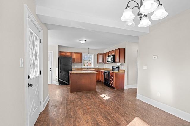 kitchen with pendant lighting, an inviting chandelier, black appliances, dark hardwood / wood-style floors, and a kitchen island