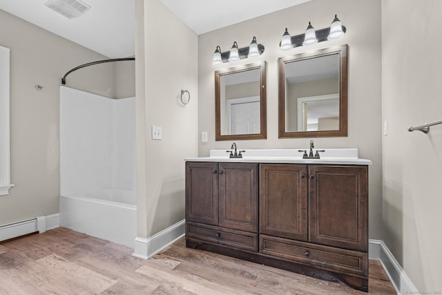 bathroom featuring hardwood / wood-style flooring, vanity, and shower / tub combination