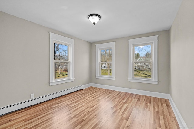 unfurnished room featuring light hardwood / wood-style flooring, plenty of natural light, and baseboard heating