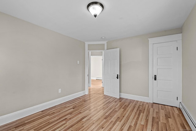 unfurnished bedroom featuring a baseboard radiator and light hardwood / wood-style floors