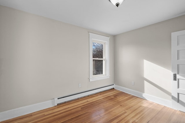 empty room with light wood-type flooring and baseboard heating