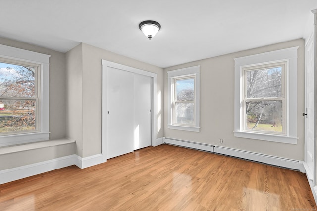 entrance foyer with light hardwood / wood-style floors, a wealth of natural light, and a baseboard radiator