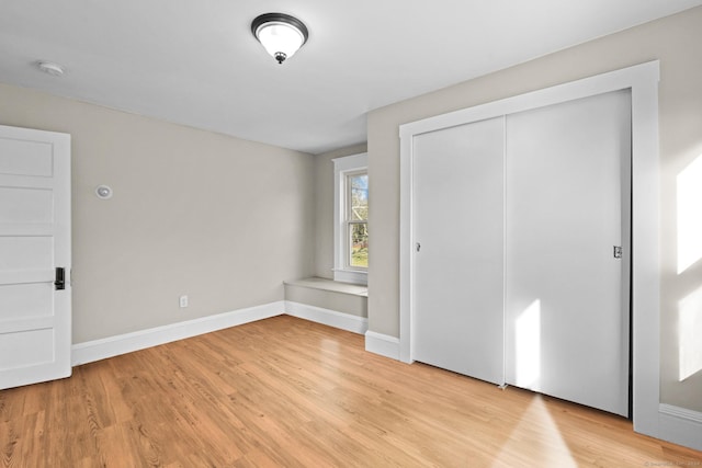 unfurnished bedroom featuring a closet and light wood-type flooring