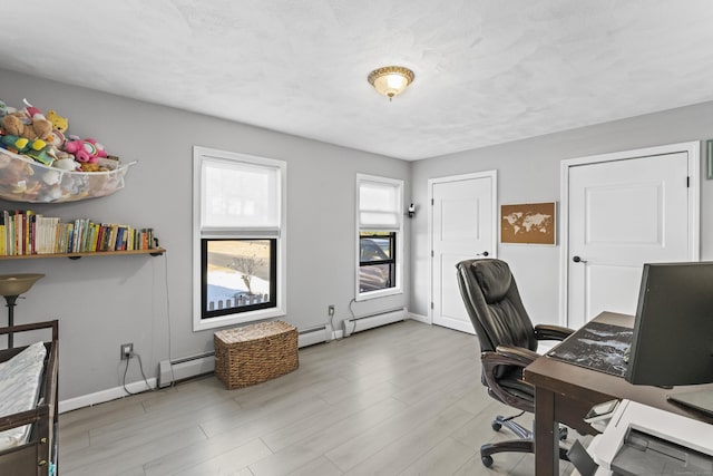 home office featuring light hardwood / wood-style floors and a baseboard heating unit