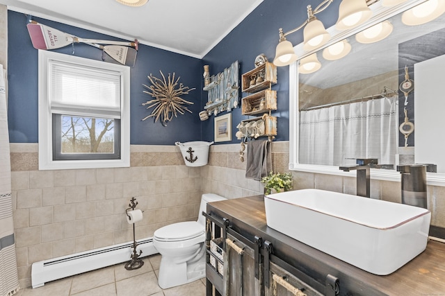 bathroom with tile patterned flooring, toilet, tile walls, and a baseboard heating unit