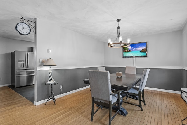 dining space with an inviting chandelier and hardwood / wood-style flooring