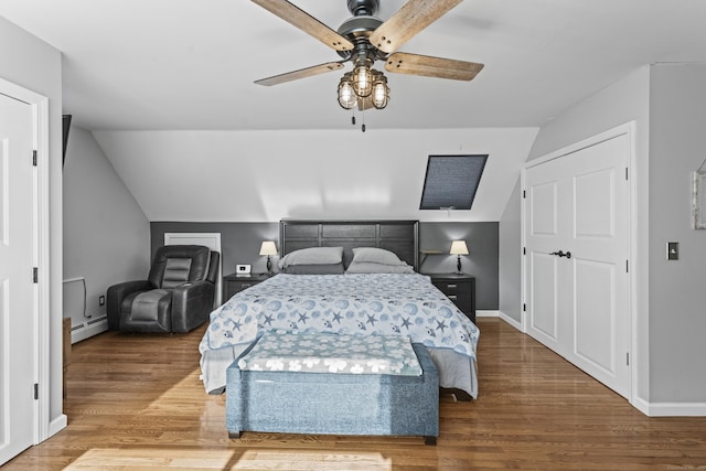 bedroom with ceiling fan, wood-type flooring, baseboard heating, and lofted ceiling