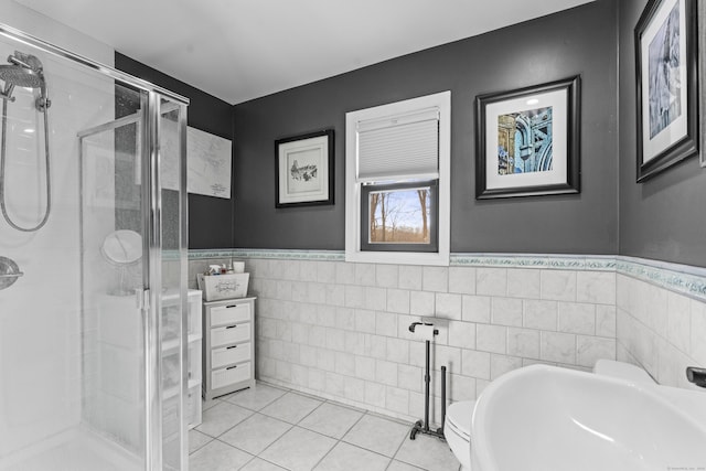 bathroom featuring sink, tile patterned floors, an enclosed shower, toilet, and tile walls