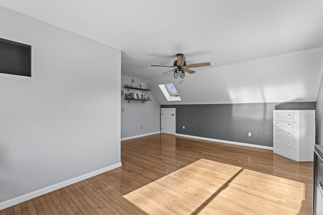 bonus room featuring vaulted ceiling with skylight, ceiling fan, and hardwood / wood-style floors