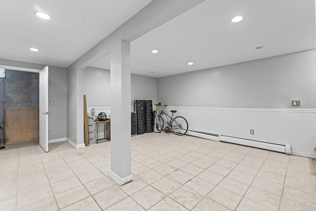 basement with a baseboard radiator and light tile patterned flooring