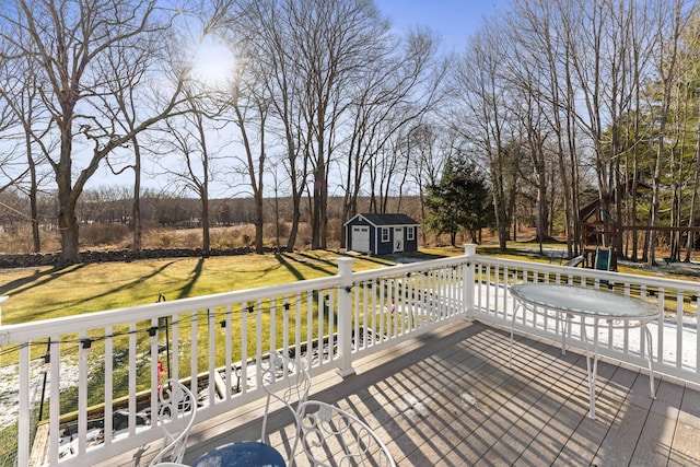 wooden deck featuring a lawn, a storage unit, and a playground