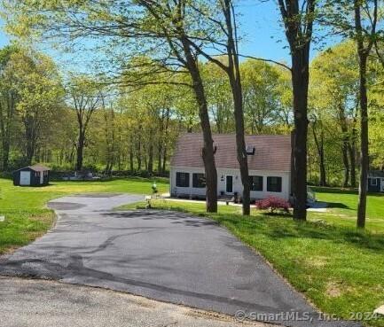 exterior space with a storage shed and a lawn