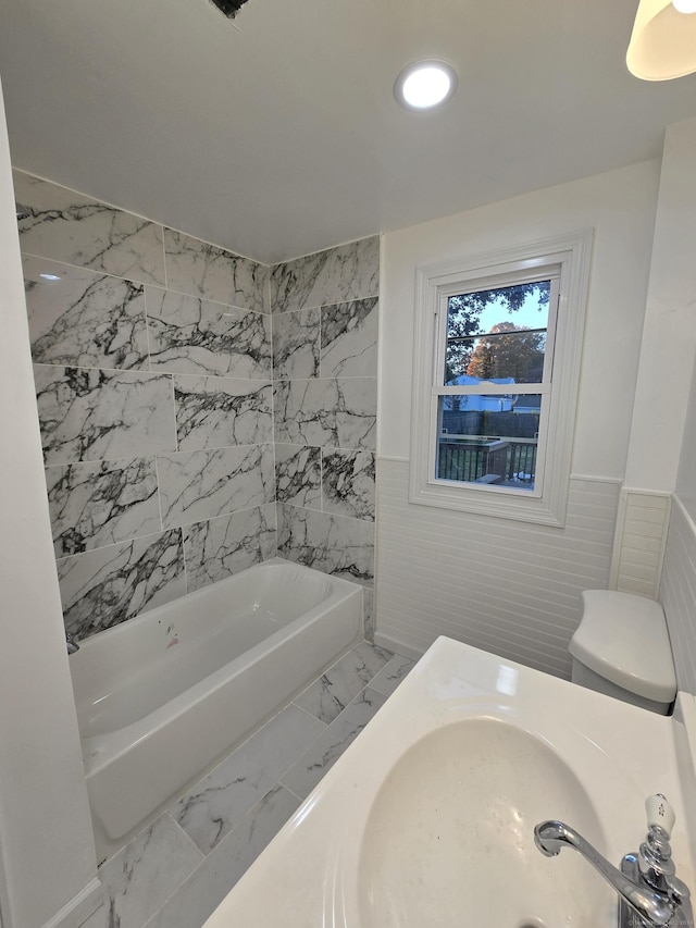 bathroom with toilet, a wainscoted wall, marble finish floor, a sink, and recessed lighting