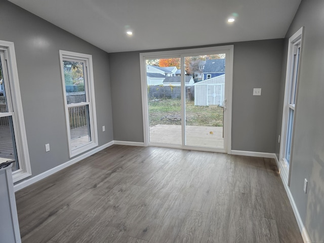 unfurnished room featuring a wealth of natural light, baseboards, and wood finished floors