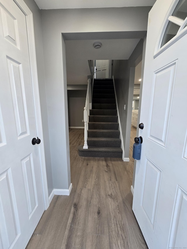 stairway featuring baseboards and wood finished floors